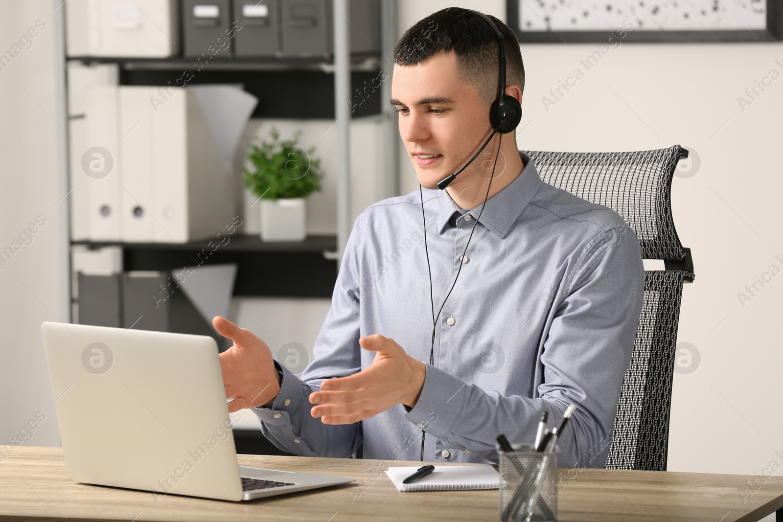 Photo of Hotline operator with headset working in office