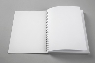 Photo of Open blank notebook on grey background. Mockup for design