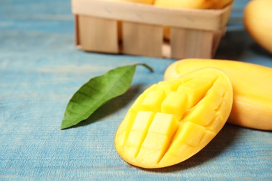 Photo of Fresh cut mango on color wooden table, closeup. Space for text