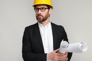 Photo of Architect in hard hat with drafts on gray background
