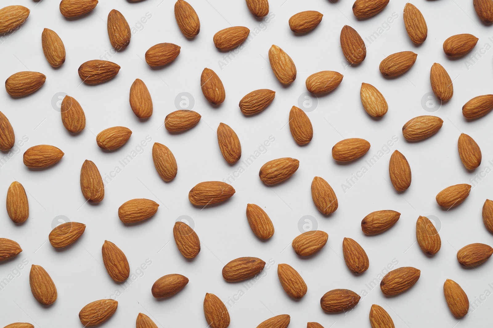 Photo of Delicious almonds on white background, flat lay