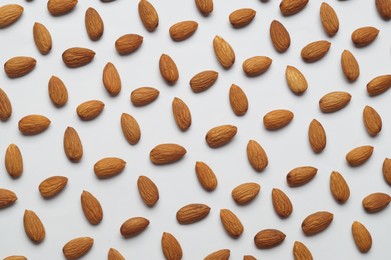 Delicious almonds on white background, flat lay