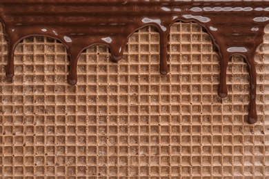 Photo of Hot dark chocolate on wafer, closeup. Crispy food