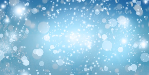 Image of Abstract snowfall on light blue background, bokeh effect. Banner design 