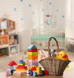 Image of Set of different cute toys on wooden table in children's room