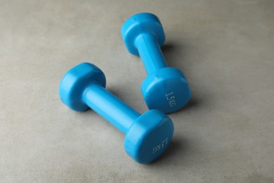 Blue vinyl dumbbells on light grey table