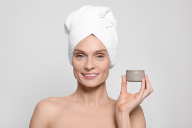 Photo of Woman with jar of body cream on white background