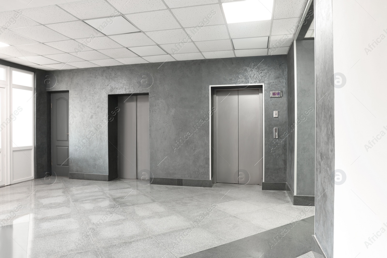 Photo of Closed stylish elevator doors in clean hall