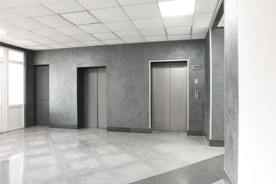 Photo of Closed stylish elevator doors in clean hall