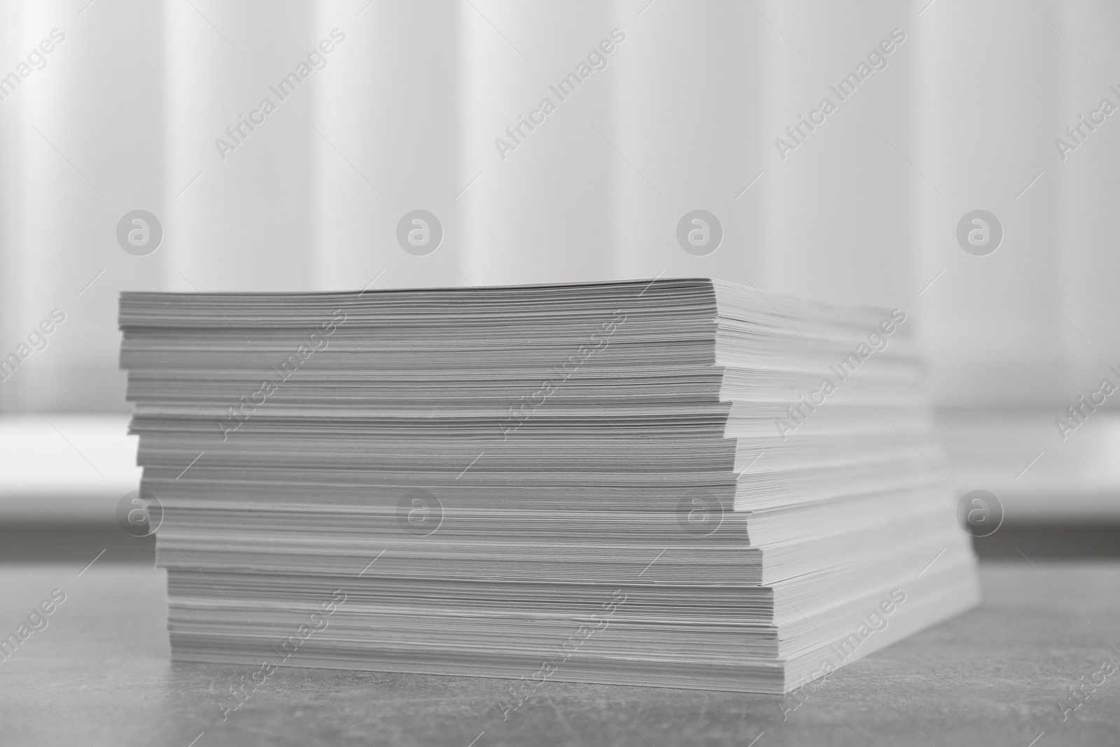 Photo of Stack of paper sheets on grey table, closeup