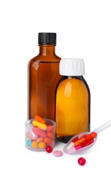 Bottles of syrups, measuring cup, plastic spoon with pills on white background. Cough and cold medicine