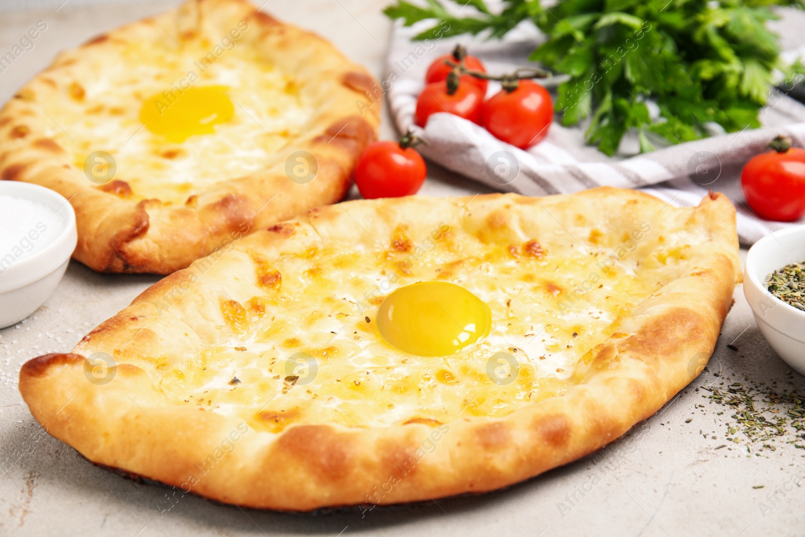 Photo of Fresh delicious Adjarian khachapuris served on light table