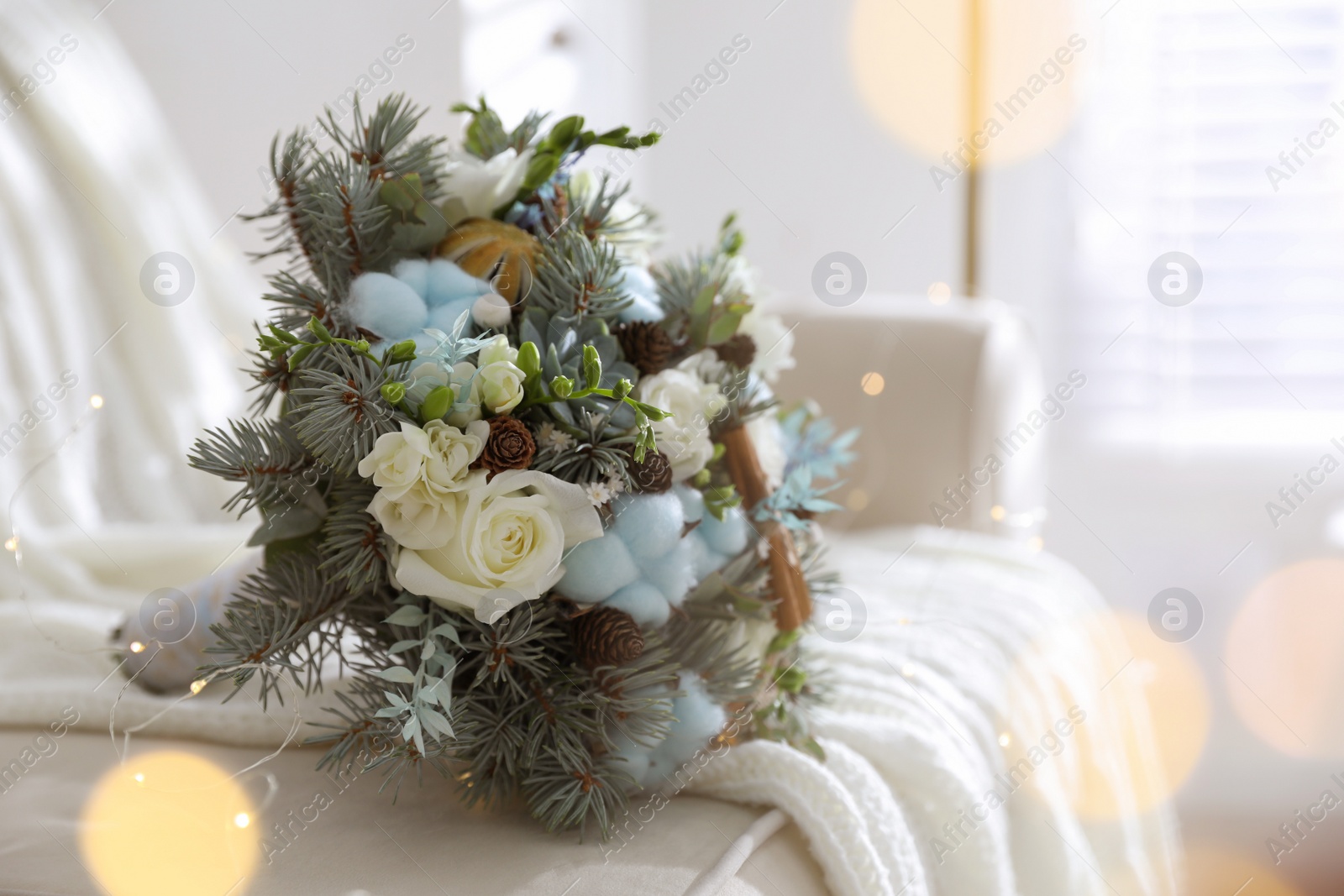 Photo of Beautiful wedding winter bouquet on sofa indoors, space for text. Bokeh effect