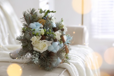 Photo of Beautiful wedding winter bouquet on sofa indoors, space for text. Bokeh effect