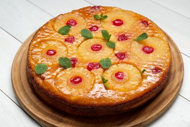 Photo of Delicious pineapple pie with cherry and mint on white wooden table
