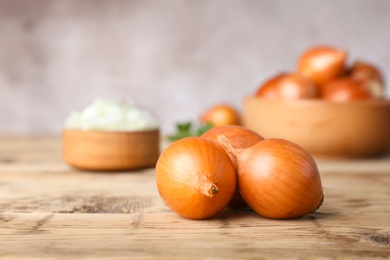 Fresh ripe onions on wooden table