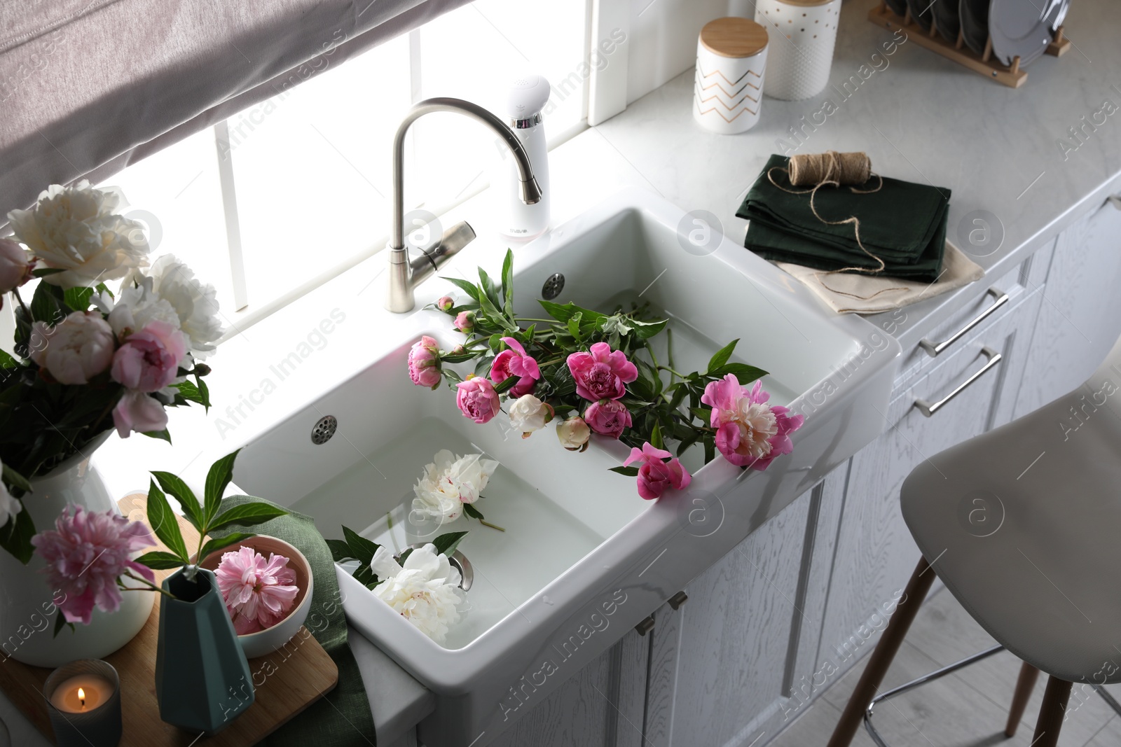 Photo of Beautiful kitchen counter design with fresh peonies