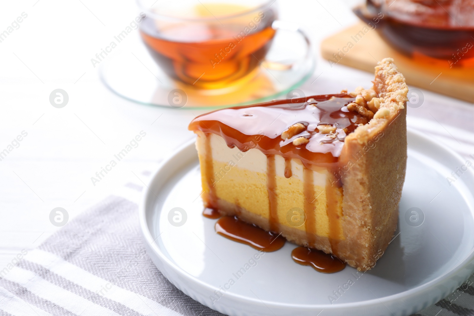 Photo of Slice of delicious cake with caramel sauce on table