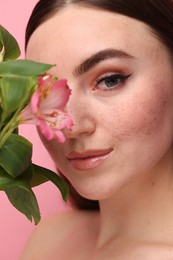 Photo of Beautiful woman with fake freckles and flower, closeup