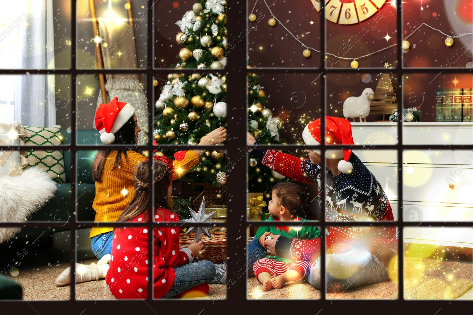 Image of Family decorating beautiful Christmas tree at home, view through window