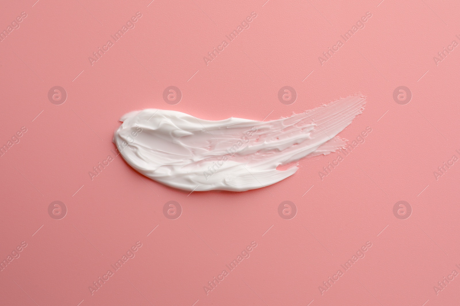 Photo of Sample facial cream on pink background, top view