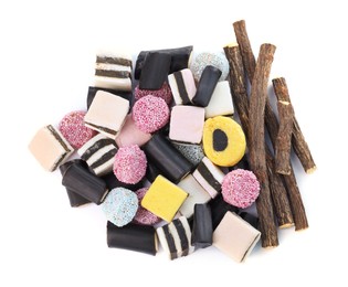 Photo of Many tasty candies and dried sticks of liquorice root isolated on white, top view