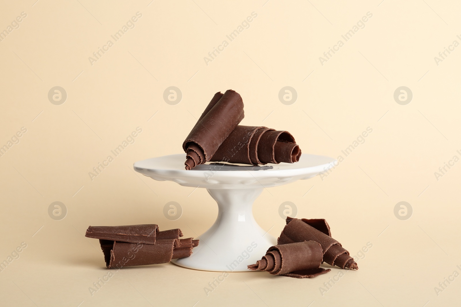 Photo of Dessert stand with chocolate curls on color background