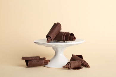 Dessert stand with chocolate curls on color background