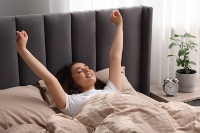 Photo of Beautiful woman stretching in soft bed at home