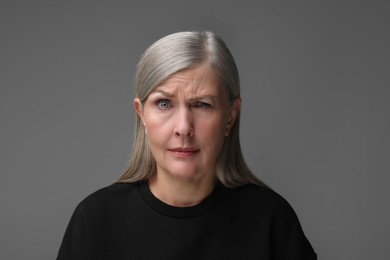 Photo of Personality concept. Portrait of woman winking on gray background