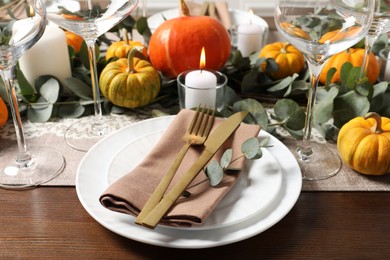 Photo of Beautiful autumn table setting. Plates, cutlery, glasses, pumpkins and floral decor