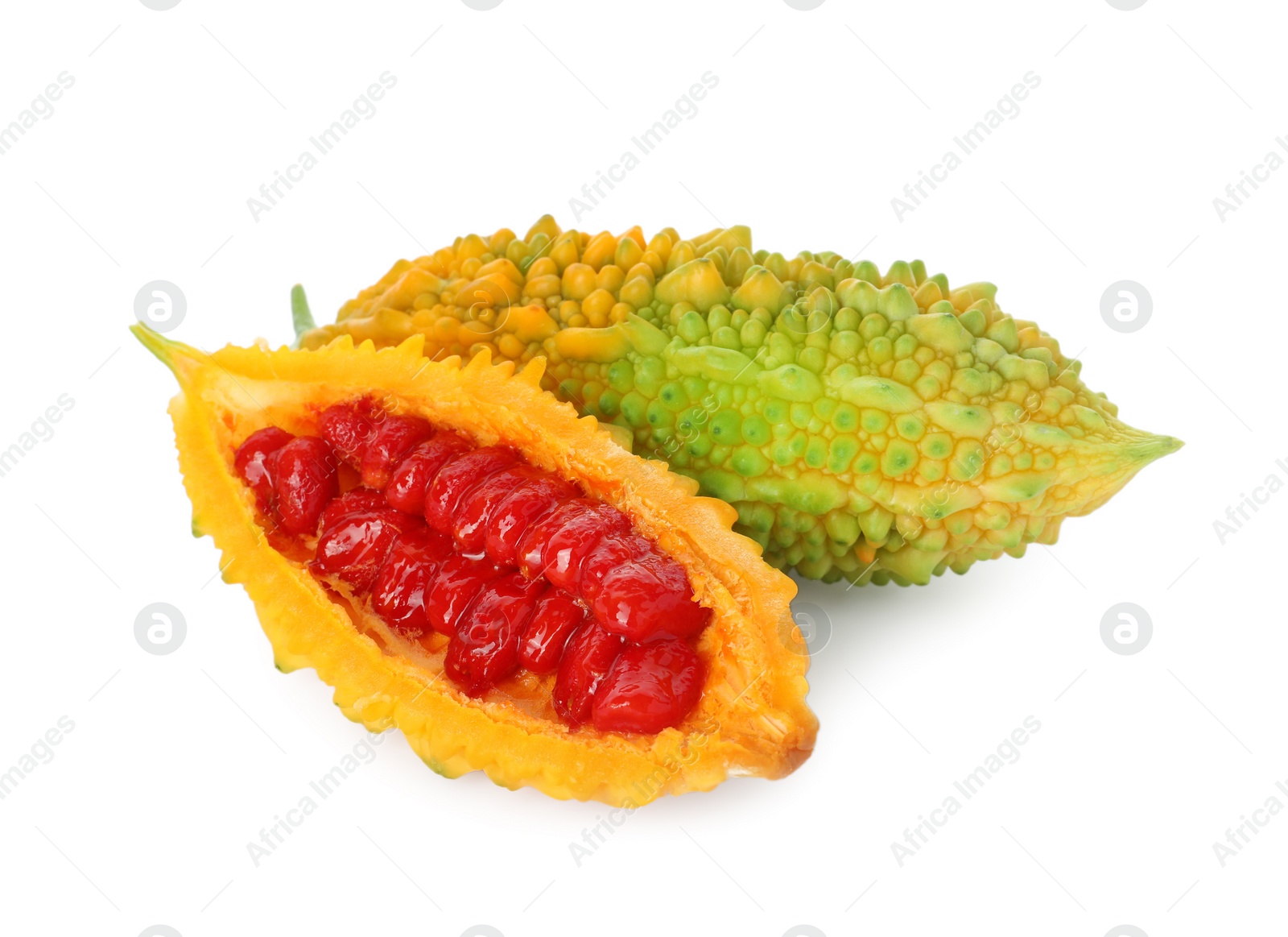 Photo of Whole and cut ripe bitter melons on white background