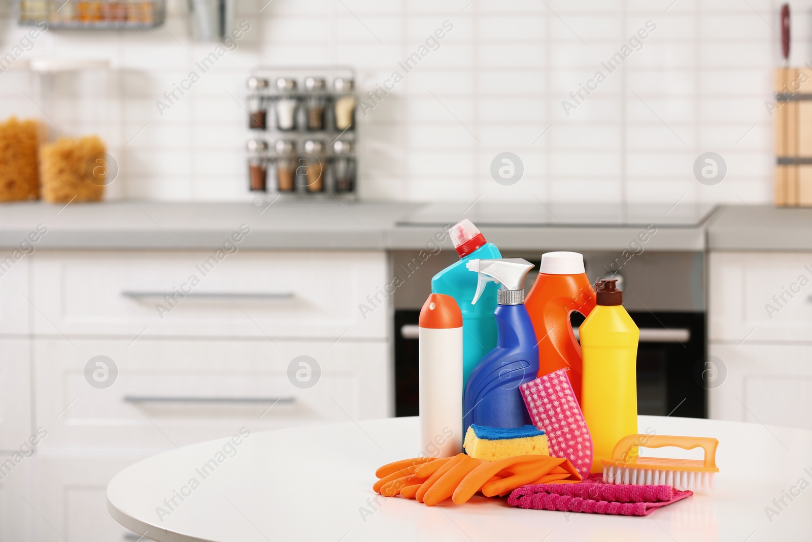 Photo of Set of cleaning supplies on table in kitchen. Space for text