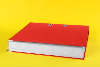 Photo of Red hardcover office folder on yellow background, closeup