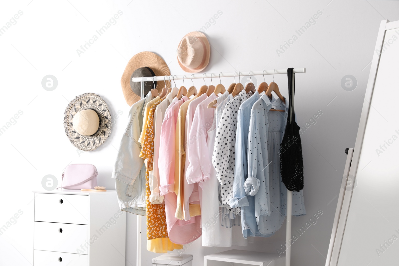 Photo of Rack with stylish women's clothes indoors. Interior design