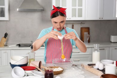 Photo of Funny woman cooking in kitchen. Dirty dishware, food and utensils on messy countertop