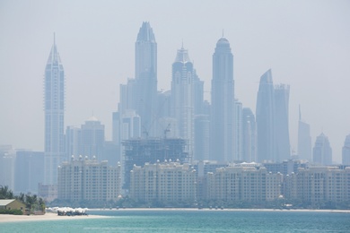 Modern and unfinished buildings in the city downtown. View from sea