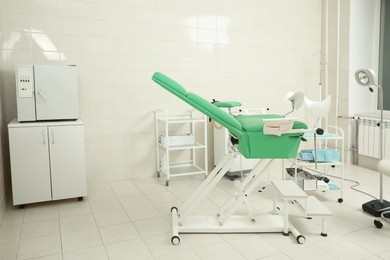 Modern gynecological office interior with examination chair and medical equipment