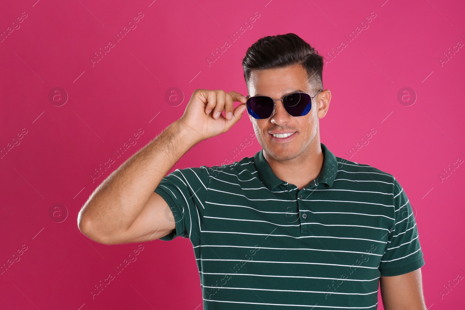 Photo of Handsome man wearing sunglasses on pink background