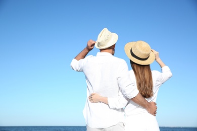 Photo of Lovely couple on sea beach, back view