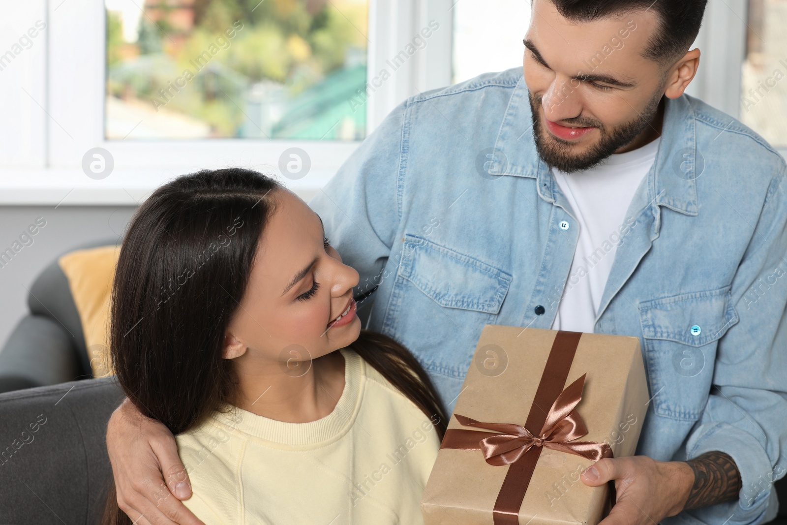 Photo of Lovely couple with beautiful gift at home