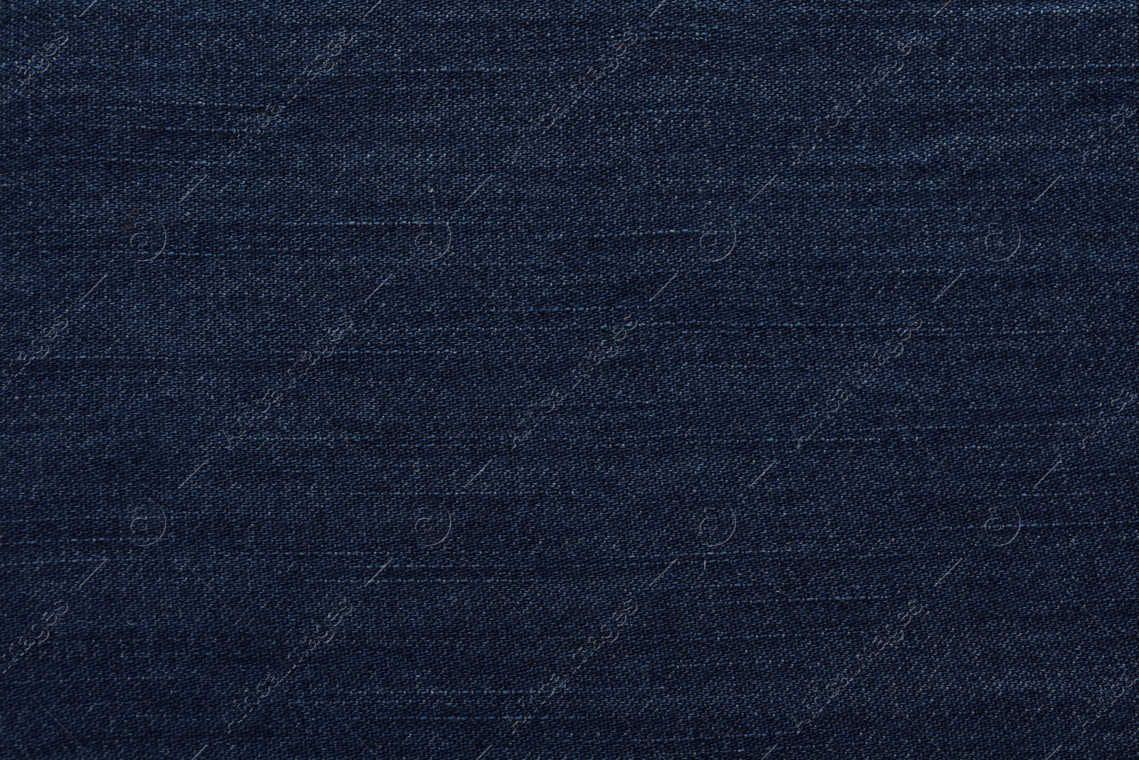 Photo of Texture of dark blue jeans as background, closeup