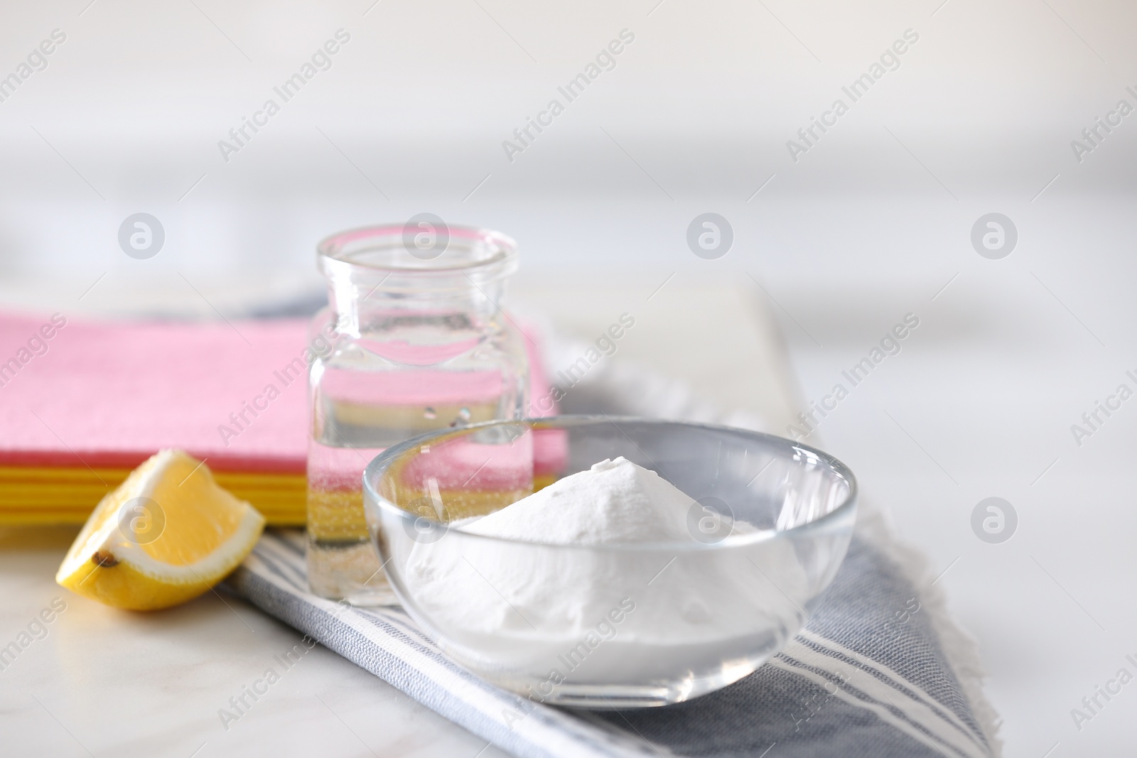 Photo of Baking soda, lemon and vinegar on white marble table. Eco friendly detergents