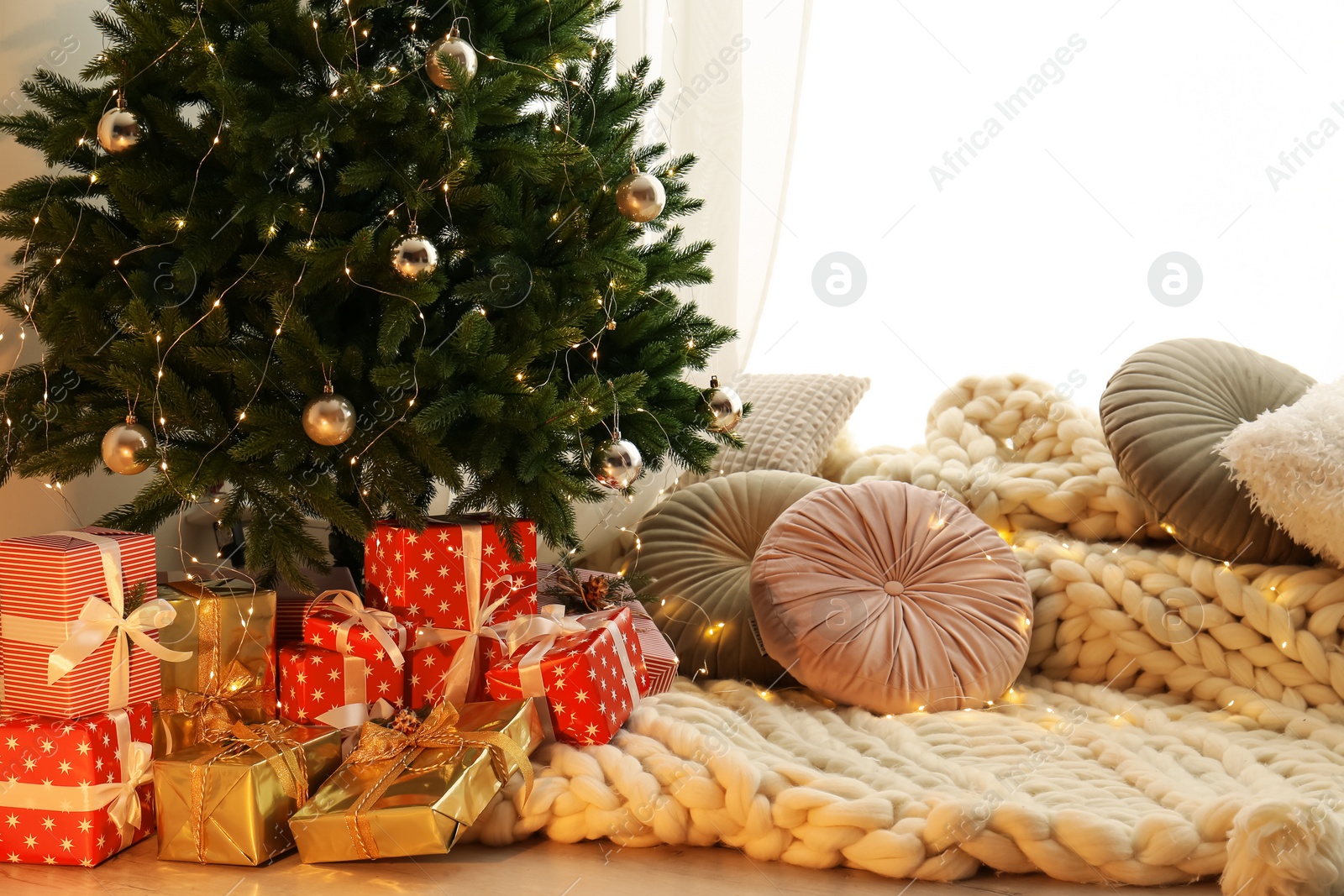 Photo of Beautiful Christmas tree and gift boxes in light room. Interior design