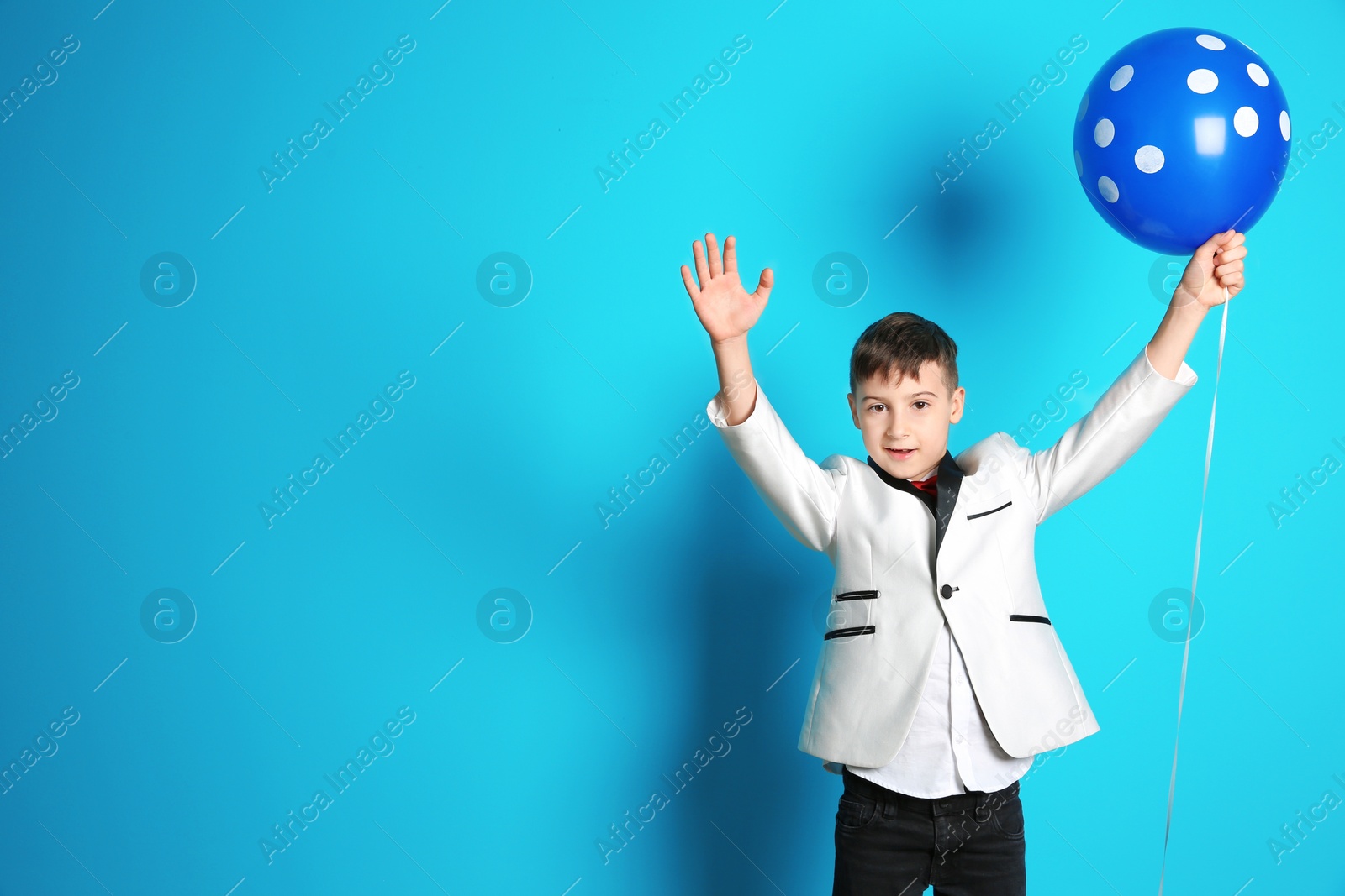 Photo of Cute boy with balloon on color background. Birthday celebration