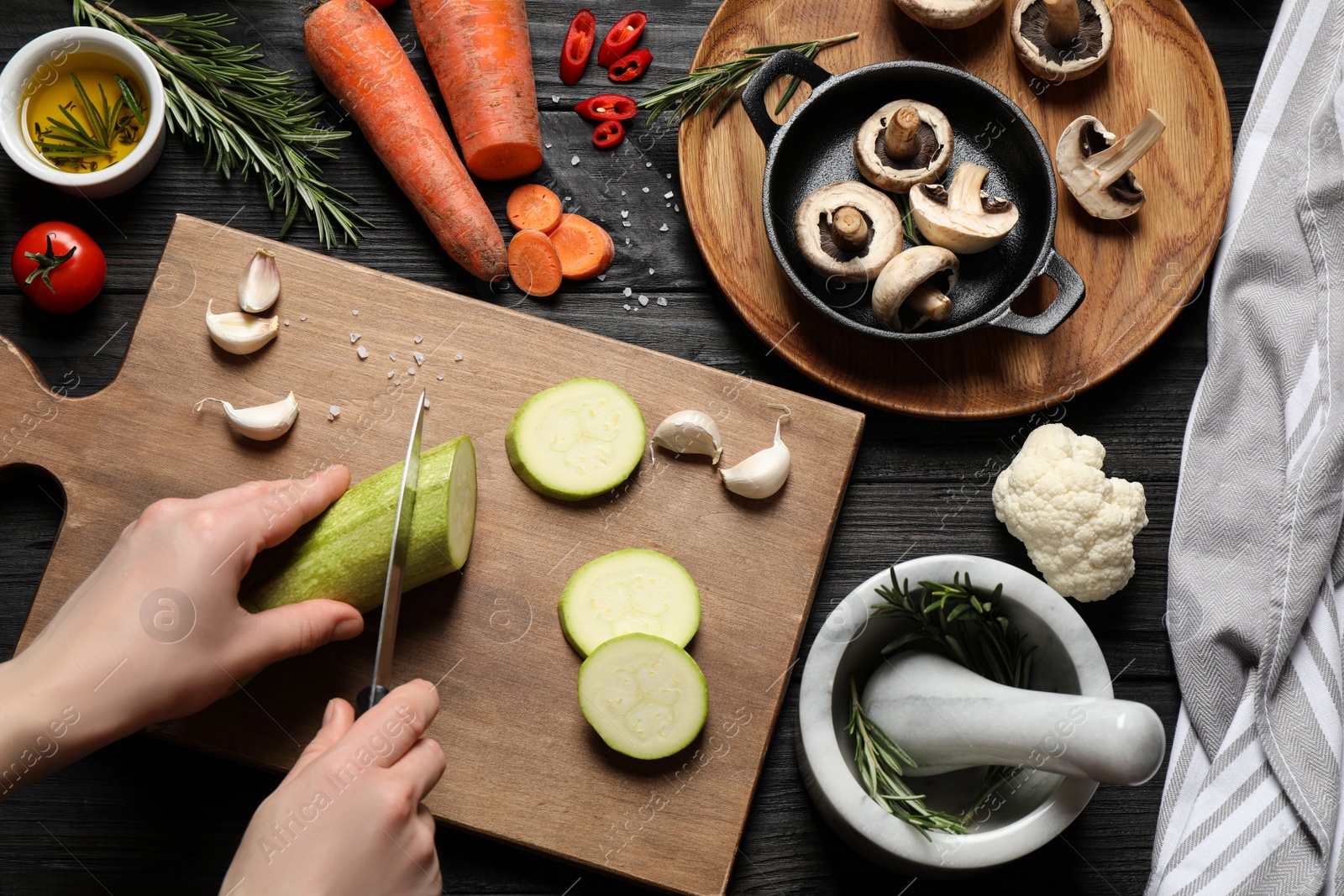 Photo of Women cooking at black wooden table, top view