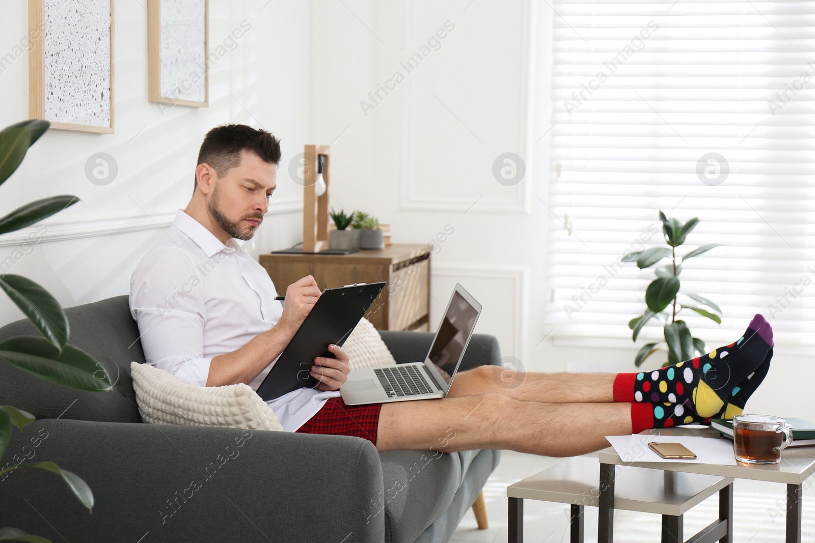 Photo of Businessman wearing shirt and underwear during video call at home