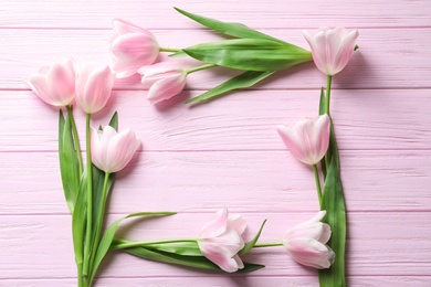 Photo of Beautiful frame made of tulips for Mother's Day on wooden background