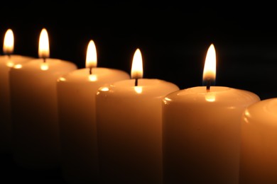 Photo of Burning candles on dark background, closeup. Memory day