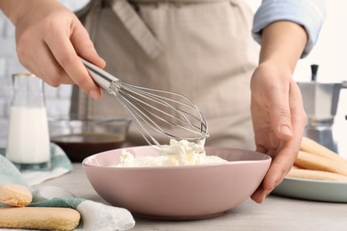 Woman making tiramisu cake at white wooden table, closeup